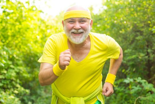  A man wearing a yellow top in a running pose facing the camera