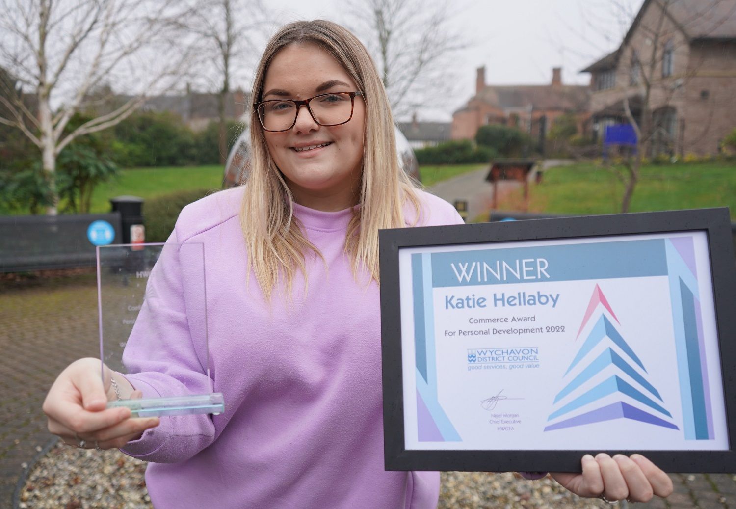 Woman holding a trophy and certificate