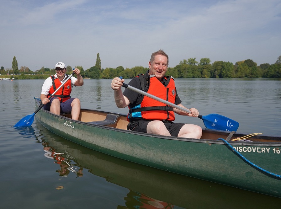 Cllr Rick Deller and Cllr Robert Raphael sat in a canoe on a lake rowing.