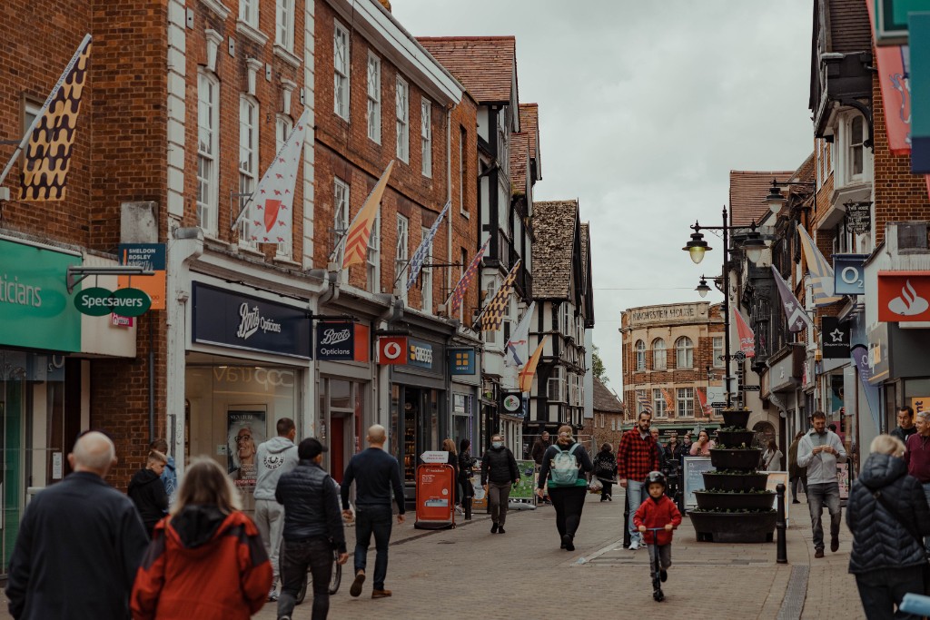 Evesham Town Centre with shops on the left and right and people walking down the middle of the street.