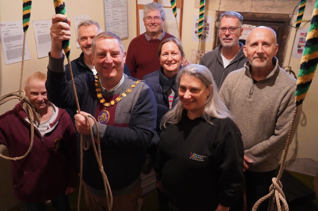 A group of people stood in a circle holding ropes.