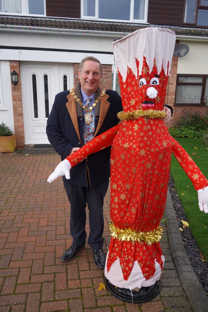 A man stood next to a life size scarecrow Christmas cracker