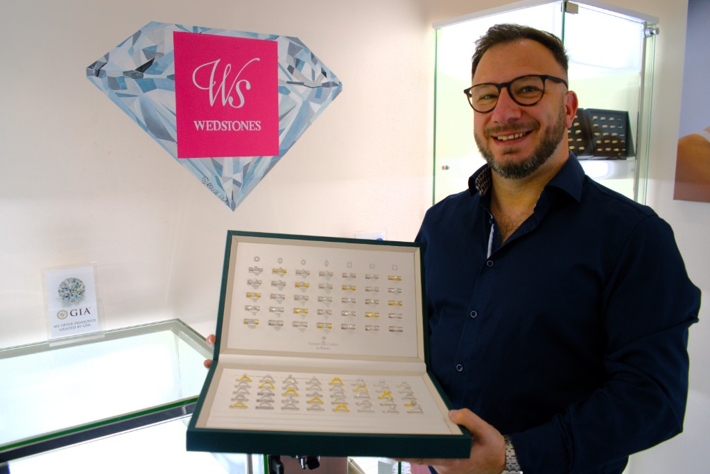 A man holding an open case of diamond rings