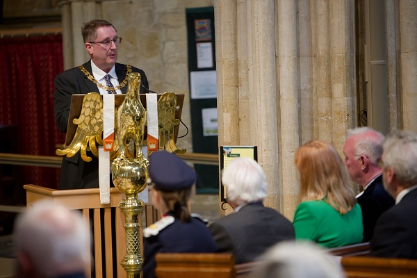 Man stood at a lectern in a church speaking