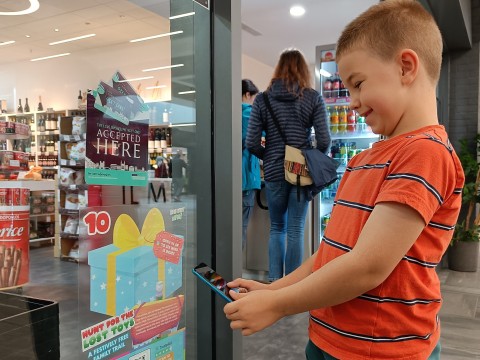 Boy taking picture of a poster using his phone