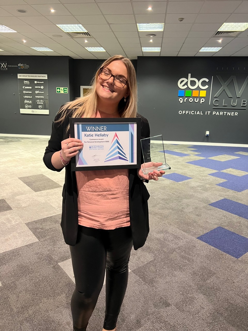 Female holding certificate and trophy looking happy